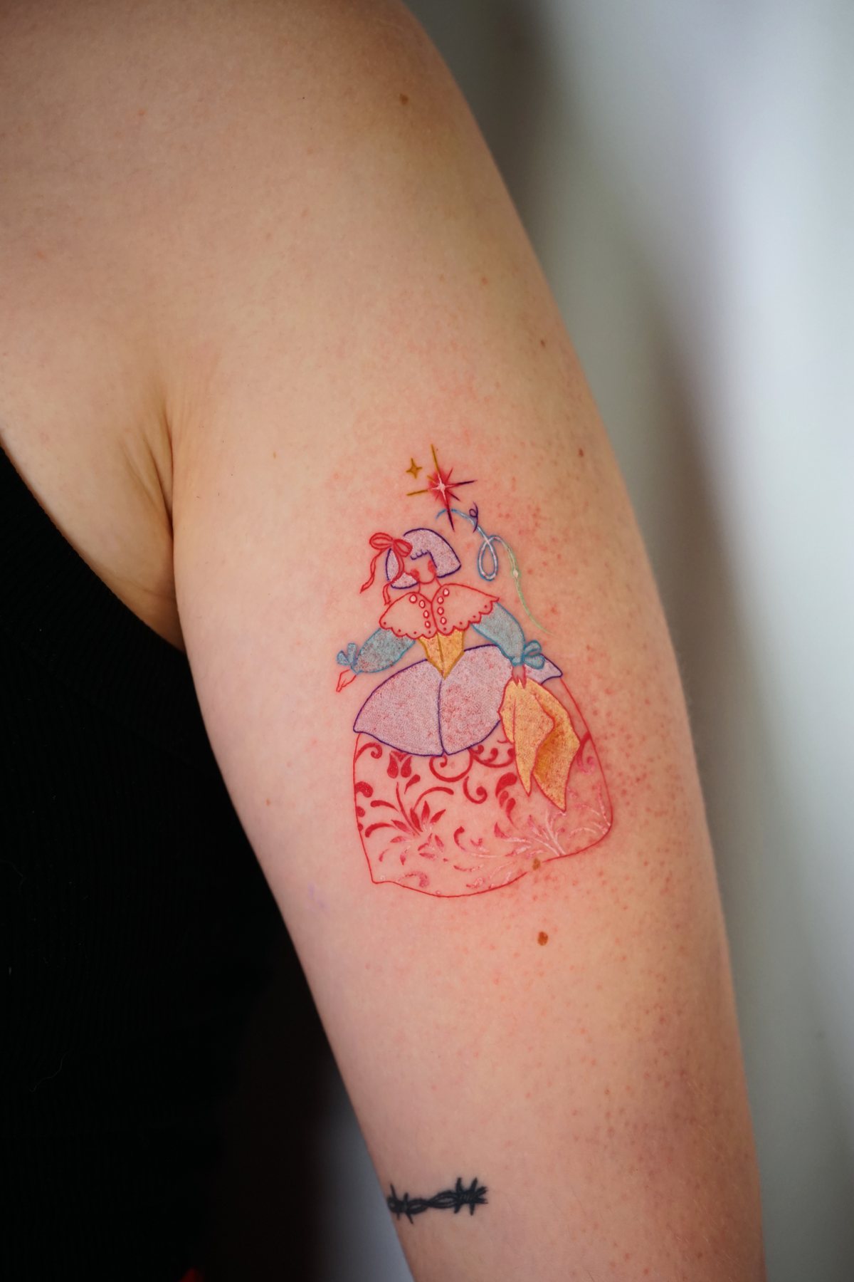 Tatuaje fineline con detalles de color de Shira Tattoo