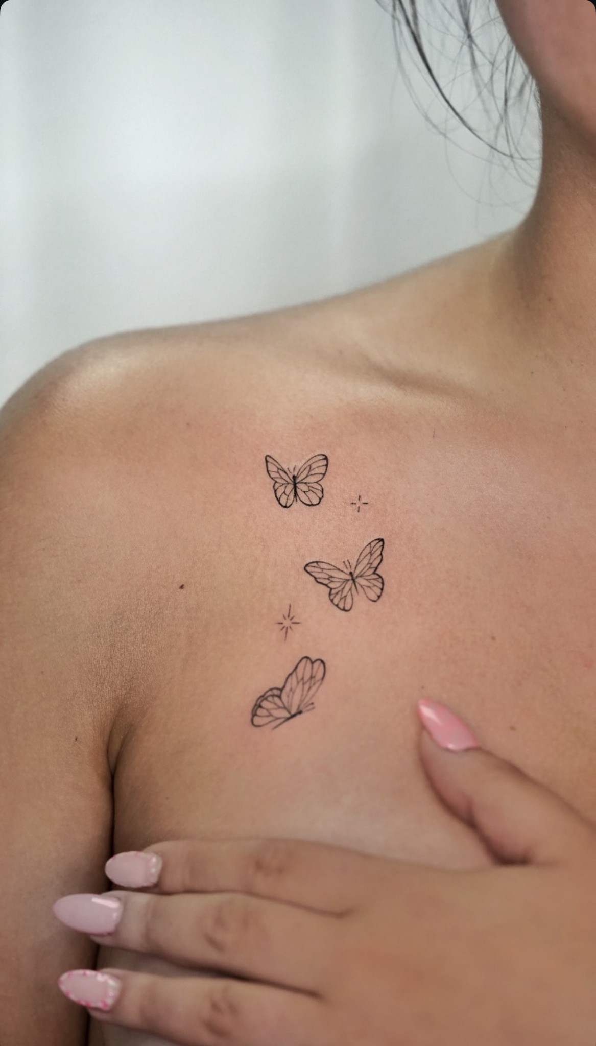 Tatuaje fineline de mariposas en la clavícula realizado por Shira Tattoo