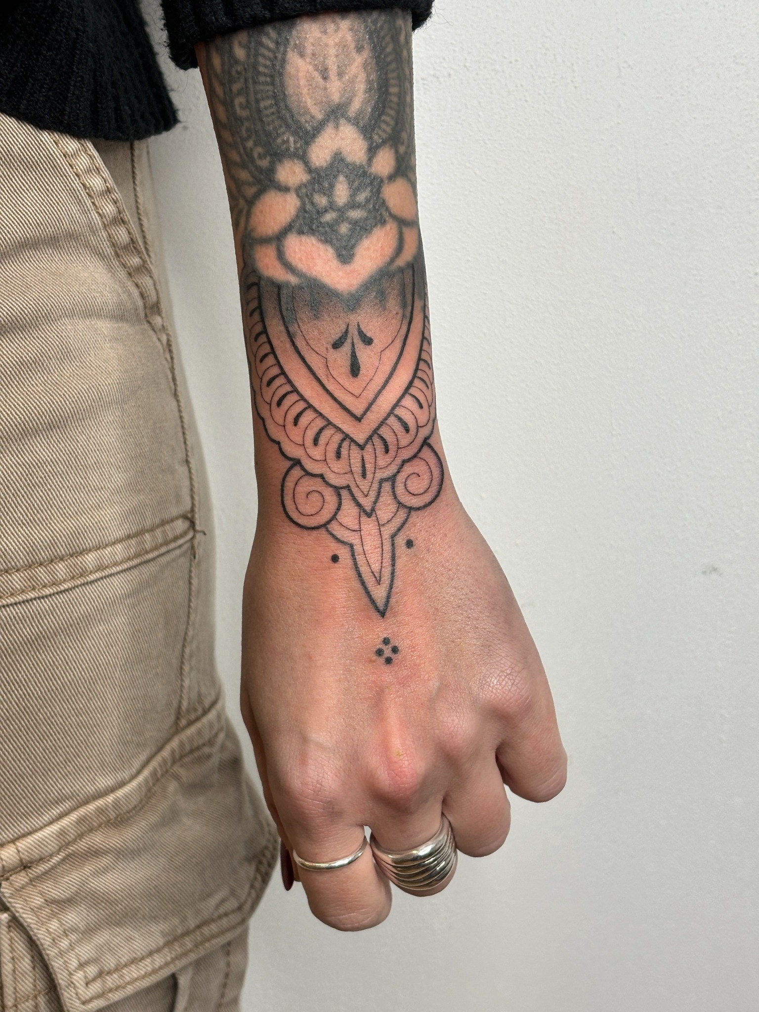 Tatuaje fineline ornamental sobre mano y muñeca realizado por Shira Tattoo
