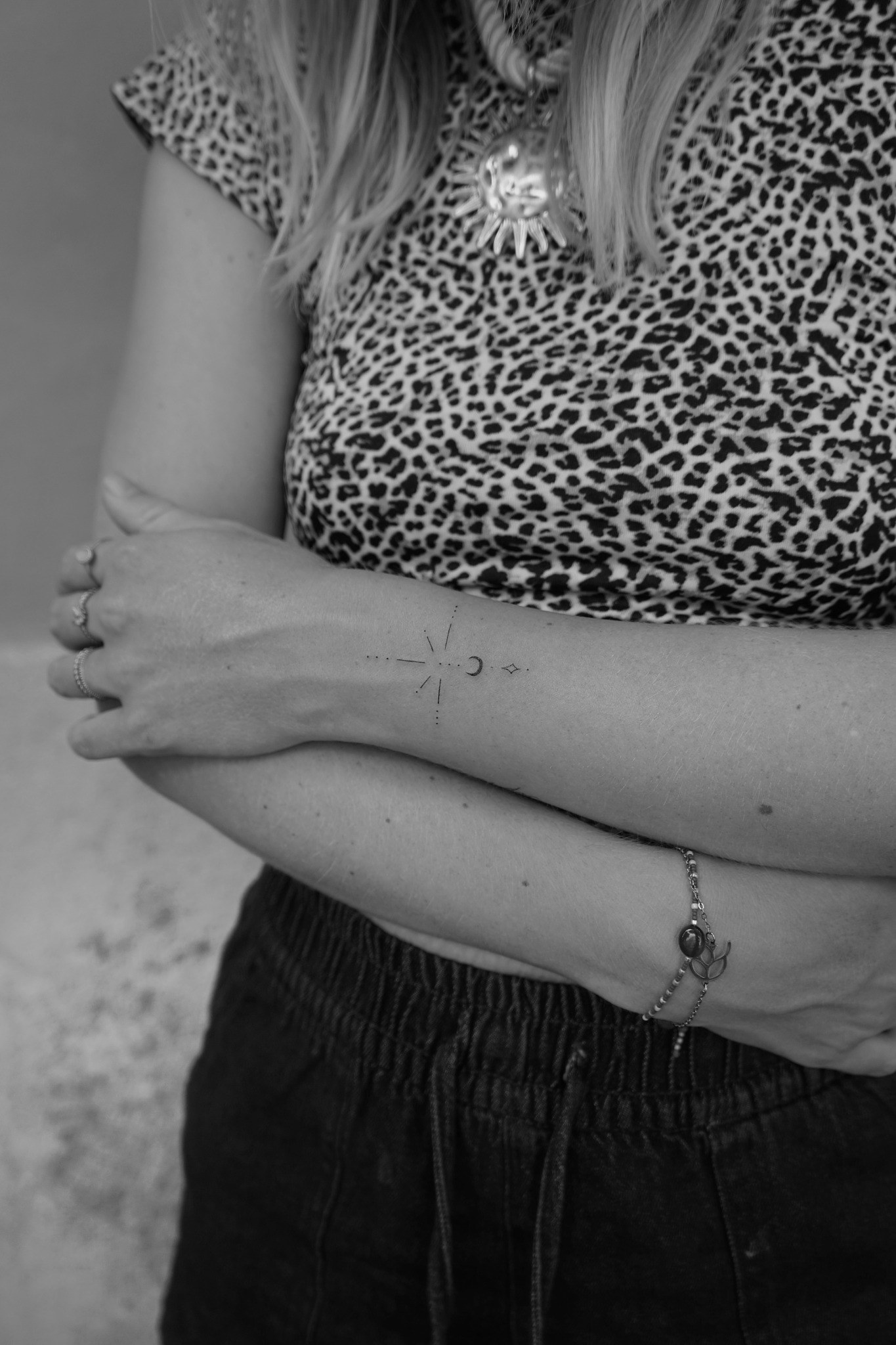 Tatuaje fineline minimalista de símbolos en el antebrazo realizado por Shira Tattoo