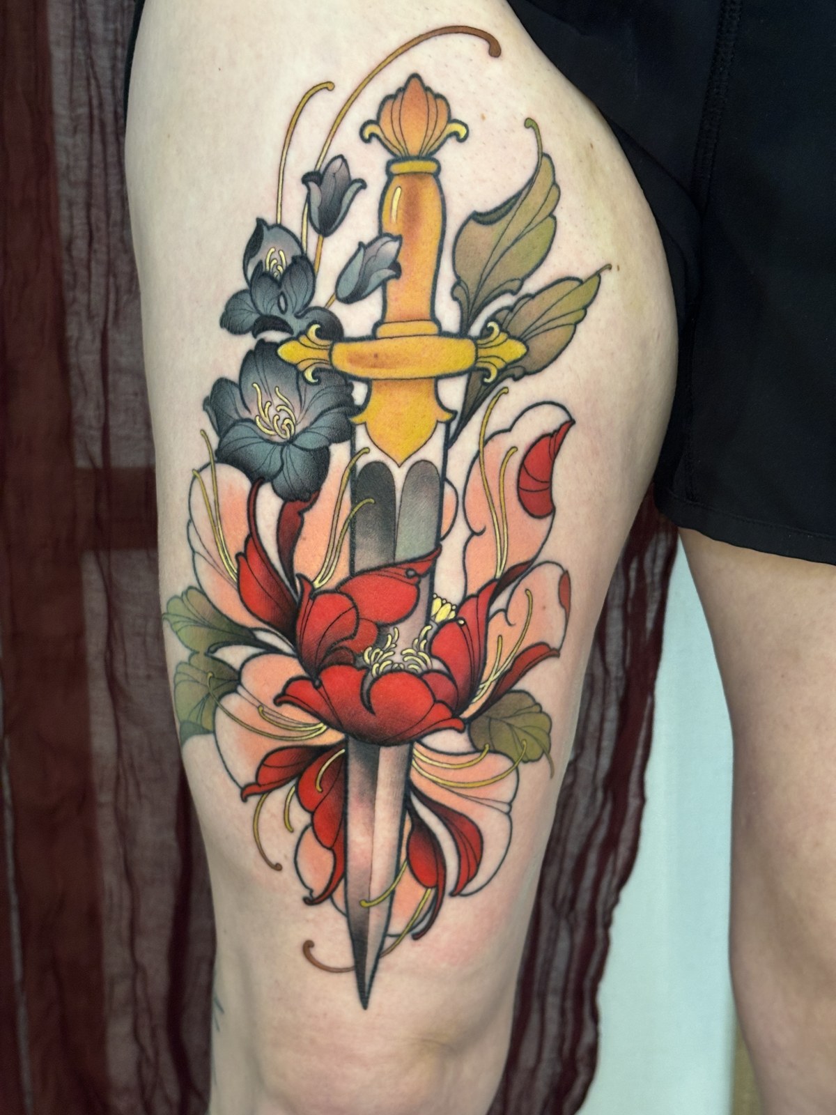 Tatuaje neotradicional de Shira: daga entre flores
